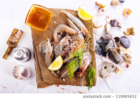 Raw tiger white shrimp prawn on board with herbs. Raw tiger white shrimp prawn on board with herbs. 119985652