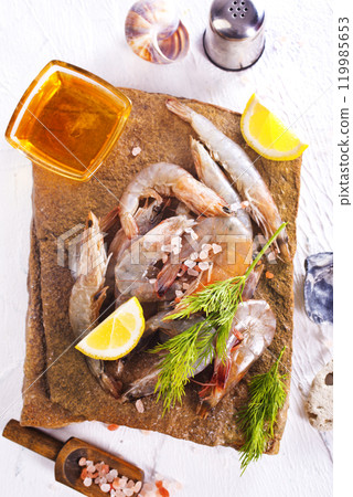 Raw tiger white shrimp prawn on board with herbs. Raw tiger white shrimp prawn on board with herbs. 119985653