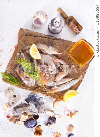 Raw tiger white shrimp prawn on board with herbs. 119985657