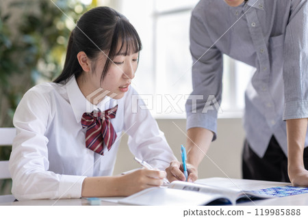 A student being taught by a tutor 119985888