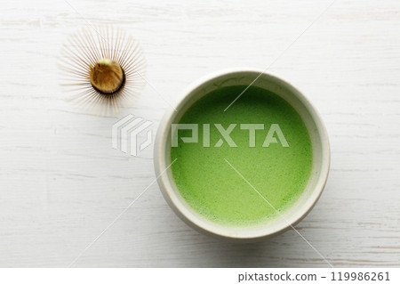 Cup of fresh matcha tea on white wooden table. 119986261