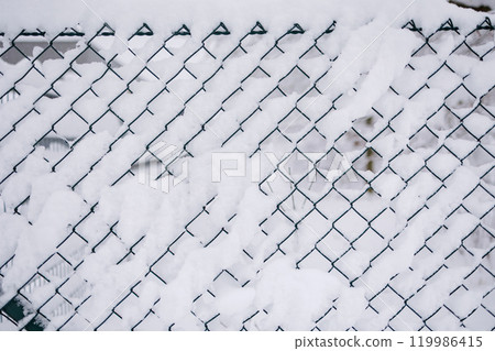 Close-up of fence covered in snow. Winter is coming.  Close-up of fence covered in snow. Winter is coming.  119986415