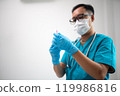 Medical Professional Preparing Syringe with Protective Mask and Gloves 119986816