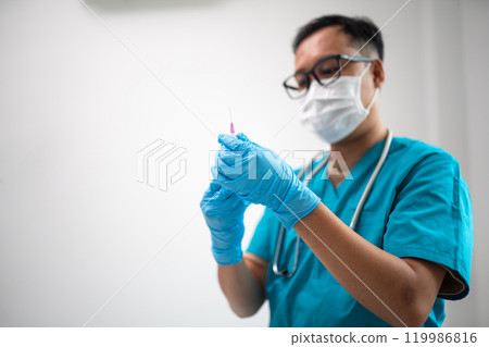 Medical Professional Preparing Syringe with Protective Mask and Gloves 119986816