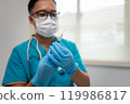 Healthcare Professional Holding Syringe with Focused Attention on Patient Care 119986817