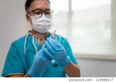 Healthcare Professional Holding Syringe with Focused Attention on Patient Care 119986817