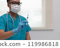 Healthcare Worker Holding Syringe in Preparation for Injection 119986818