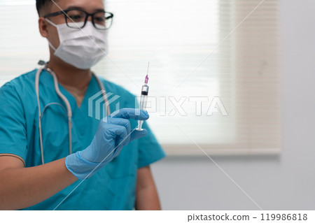 Healthcare Worker Holding Syringe in Preparation for Injection 119986818