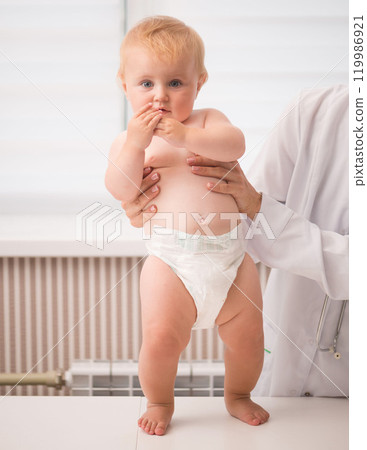 doctor hands holdin a baby on a table in a hospital 119986921