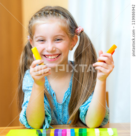 Little girl playing with plasticine at home 119986942