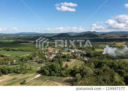 The aerial picture of Hui Kha Khaeng atmosphere, green forest and mountains, in Tak province, Thailand. The enormous wildlife sanctuary environment with sunlight and clouds on the blue sky. The aerial picture of Hui Kha Khaeng atmosphere, green forest and mountains, in Tak province, Thailand. The enormous wildlife sanctuary environment with sunlight and clouds on the blue sky. 119987177