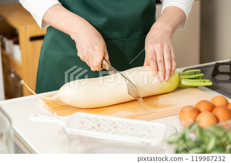 中年婦女用刀切蘿蔔的手 中年婦女用刀切蘿蔔的手 119987232