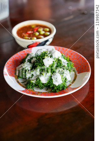 Bai Chakram with coconut cream served with Nam Prik Kapi or Thai shrimp paste chili sauce in the local restaurant. A famous healthy menu in Tambon Yi san, Samut Songkhram. 119987342
