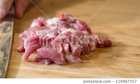 Close up of chef Butcher cutting pork meat with knife on kitchen, cooking food. The chef butcher preparing pork meat for cooking. Close up of chef Butcher cutting pork meat with knife on kitchen, cooking food. The chef butcher preparing pork meat for cooking. 119987357