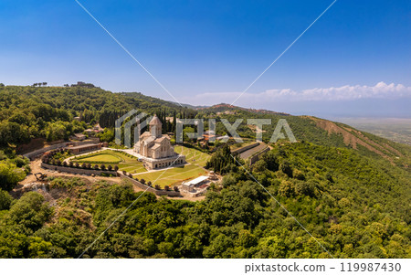 Aerial top view of the Bodbe Monastery architectural complex of St. Nino. View from above to church, Alazani Valley, Greater Caucasus mountains, in sunny summer day. Sighnaghi city, Kakheti, Georgia. Aerial top view of the Bodbe Monastery architectural complex of St. Nino. View from above to church, Alazani Valley, Greater Caucasus mountains, in sunny summer day. Sighnaghi city, Kakheti, Georgia. 119987430