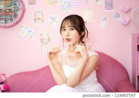 Young woman in wedding dress (Fancy photo props room) 119987597