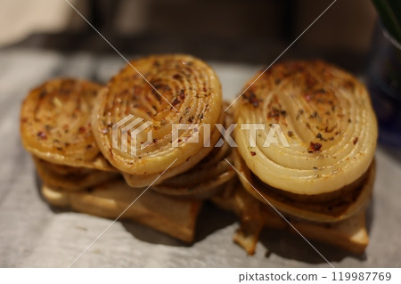 Delicious Caramelized Onions Stacked Generously on Hearty Rustic Bread for Enjoyment 119987769