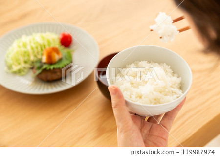 Middle-aged to senior women eating a hamburger steak set meal 119987974