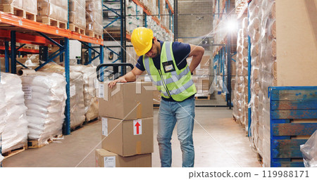 Back pain, man and boxes in warehouse for injury, overworked and strain with inventory. Logistics, male worker and backache in factory for export, commerce and packaging for trade or shipping 119988171