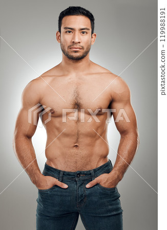 Man, body and portrait in studio with abs or muscles, shirtless and grey background with model or bodybuilder. Jeans, strong chest and Asian male person on backdrop, confidence with six pack 119988191