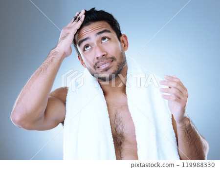 Man, thinking and haircare with towel for hygiene, skincare and grooming in blue background. Male person, clean and healthy for wellness, confidence and cosmetic with happiness in studio backdrop 119988330