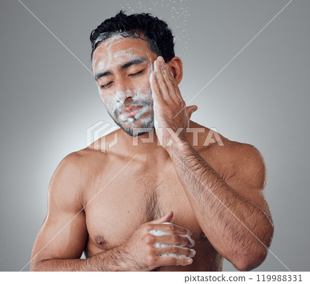 Man, shower and soap for washing face in studio, water and cleaning or grooming on gray background. Male person, cosmetics and foam for dermatology in morning routine, skincare and facial treatment Man, shower and soap for washing face in studio, water and cleaning or grooming on gray background. Male person, cosmetics and foam for dermatology in morning routine, skincare and facial treatment 119988331