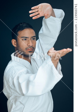 Training, karate and man in martial arts on studio, black background and practice exercise. Fight, gesture and person with skill in self defence technique, action or fighter in sport with hands 119988741
