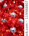 Background Silver mirror disco balls toys and lights on red indoor Christmas tree for New Year 119988807