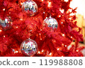 Silver mirror disco balls toys and lights on red indoor Christmas tree for new year 119988808