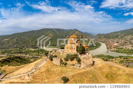 Aerial top view of ancient Jvari Monastery is a VI century Georgian Orthodox monastery. Holy Cross church is Early Medieval Georgian. Confluence of Kura and Aragvi. Tbilisi, Mtskheta, Georgia, Europe. Aerial top view of ancient Jvari Monastery is a VI century Georgian Orthodox monastery. Holy Cross church is Early Medieval Georgian. Confluence of Kura and Aragvi. Tbilisi, Mtskheta, Georgia, Europe. 119988903
