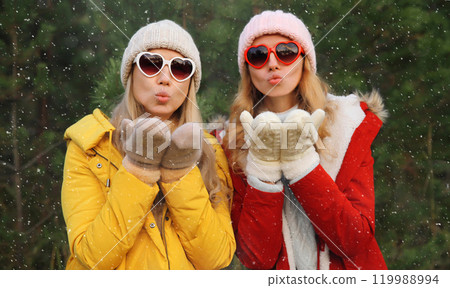 Happy women friends having fun, celebration, girlfriends on Christmas tree in winter with snow Happy women friends having fun, celebration, girlfriends on Christmas tree in winter with snow 119988994