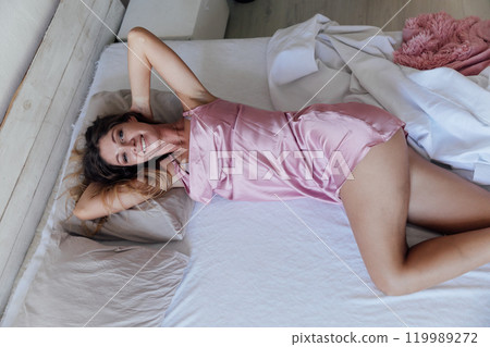 Beautiful woman in lingerie woke up in the morning in the bedroom on the bed Beautiful woman in lingerie woke up in the morning in the bedroom on the bed 119989272