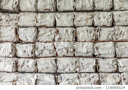 The natural Thai standard rubber bales sheet products staked and stored in the factory warehouse. The storage procession product of a rubber factory. 119989324