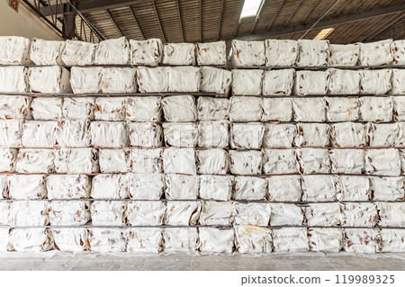 The natural Thai standard rubber bales sheet products staked and stored in the factory warehouse. The storage procession product of a rubber factory. 119989325