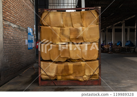 In the production process, the natural rubber sheets were air dried on hanging steel rail near the brick wall of the factory. In the production process, the natural rubber sheets were air dried on hanging steel rail near the brick wall of the factory. 119989328
