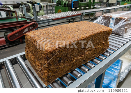 The natural rubber bales products on the industrial automatic conveyor belt machine in a rubber factory. The natural rubber bales products on the industrial automatic conveyor belt machine in a rubber factory. 119989331
