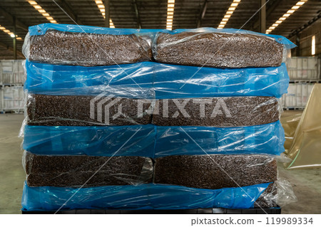 Natural rubber packaged in the plastic sacks, prepared for export delivery, at the distribution center of a rubber company. 119989334