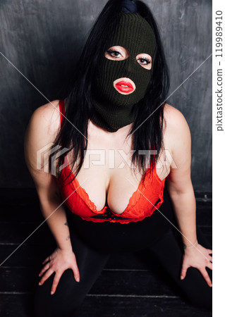 Portrait of a beautiful woman in red lingerie and black mask Portrait of a beautiful woman in red lingerie and black mask 119989410