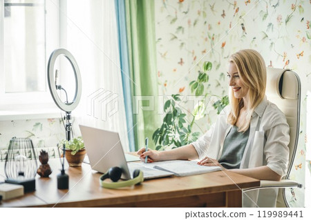 ideal setting with a ring light illuminating the desk and laptop for content creation ideal setting with a ring light illuminating the desk and laptop for content creation 119989441