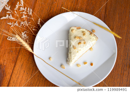 Coconut Cream Pie in the white dish on the wood table that topping with macademia. Shooting in the sunlight. 119989491