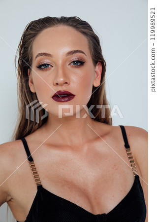 Portrait of a beautiful fashionable slender woman in black lingerie on a white background Portrait of a beautiful fashionable slender woman in black lingerie on a white background 119989521