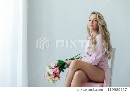 fashionable woman in light pink dress with bouquet of flowers fashionable woman in light pink dress with bouquet of flowers 119989537