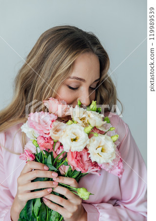 fashionable woman in light pink dress with bouquet of flowers fashionable woman in light pink dress with bouquet of flowers 119989539