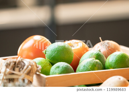 close up fresh green lime and tomato in glass bowl in studio light at kitchen. close up fresh green lime and tomato in glass bowl in studio light at kitchen. 119989683