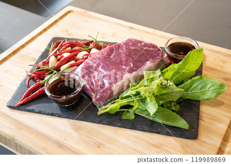 Close up, Raw Beef herb ingredients, basil, garlic, chilli, sauces are prepared on black slate plate for cooking Thai food menu, Stir-fried beef basil. 119989869