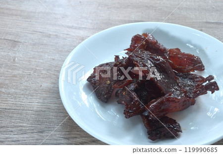 salty and sweet dry fried slice beef meat fermenting in sesame oil and pepper on plate salty and sweet dry fried slice beef meat fermenting in sesame oil and pepper on plate 119990685