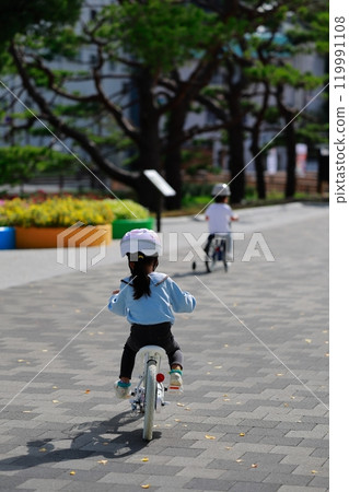 Girls practicing bicycles 119991108