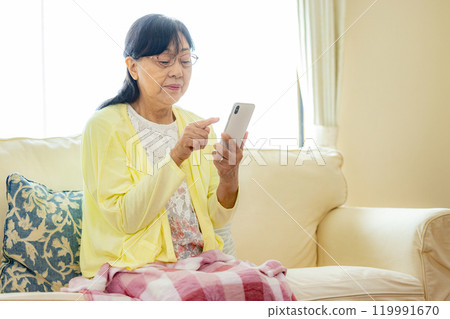 Senior woman operating a smartphone 119991670