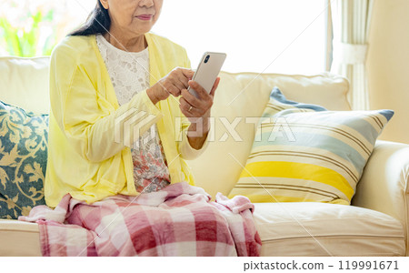 Senior woman operating a smartphone 119991671