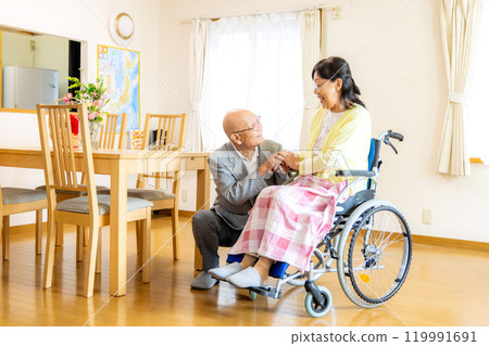 Senior woman sitting in a wheelchair, couple Senior woman sitting in a wheelchair, couple 119991691
